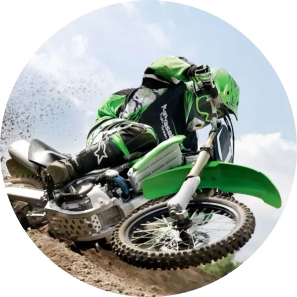 Kulatý jedlý obrázek na dort – Závodník na motorce v zatáčce (zelená, hnědá, modrá)