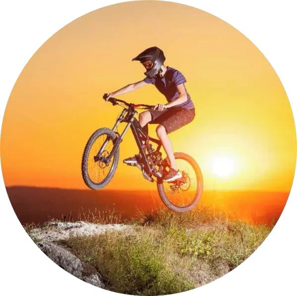Kulatý jedlý obrázek na dort – Cyklista, Kolo, skok ze skály při západu (žlutá, červená, černá)